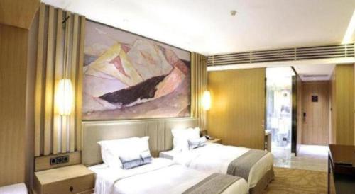 a hotel room with two beds and a painting on the wall at Ramada by Wyndham Zhengzhou East in Zhengzhou