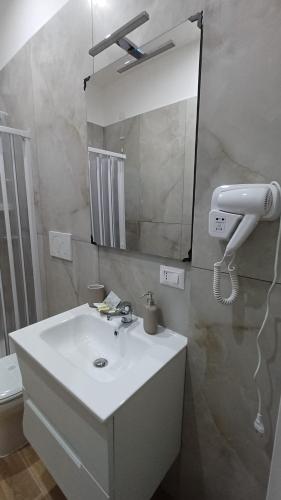 a bathroom with a white sink and a mirror at Orfeo Guest House in Modugno