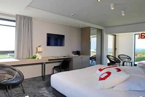 a hotel room with a bed and a desk with chairs at Hostellerie de la Pointe Saint-Mathieu - SPA & Restaurant in Plougonvelin