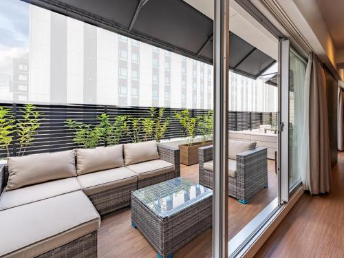 a balcony with a couch and a glass table at Sakura Terrace The Gallery in Kyoto