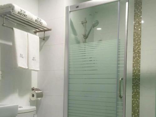 a shower with a glass door in a bathroom at Metro Winner Hotel in Hong Kong