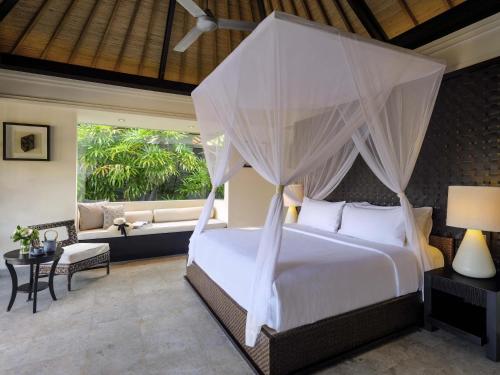 un dormitorio con una cama y un sofá en Peppers Seminyak, en Seminyak