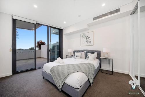 a bedroom with a large bed and a large window at KozyGuru | Thornleigh | Nice Cosy Close to All in Thornleigh