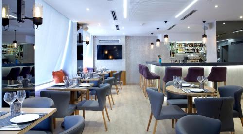 a restaurant with tables and chairs and a bar at Athens Tiare by Mage Hotels in Athens