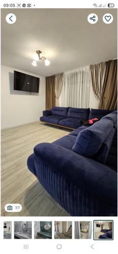 a living room with blue couches and a tv at ZenHome in Craiova