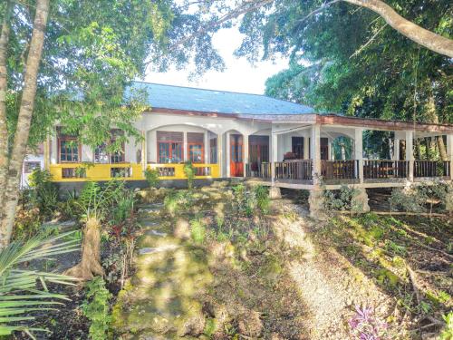 una casa gialla con portico e alberi di Amara Resort - Sunset Suite a Ohoililir