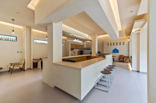 a large kitchen with a counter and stools at Buyandujiajinpinminsu in Mount Siguniang