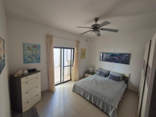 a bedroom with a bed and a ceiling fan at LA court in Marsascala in Marsaskala