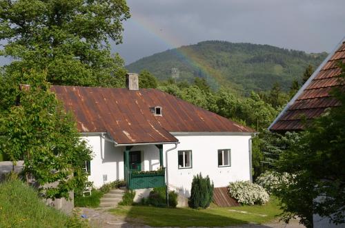 ein weißes Haus mit rotem Dach mit Regenbogen im Hintergrund in der Unterkunft Ferienwohnung Vonwald in Michelbach