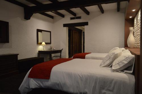 a hotel room with two beds and a table at Radisson Hotel Tapatio Guadalajara Aeropuerto in Guadalajara