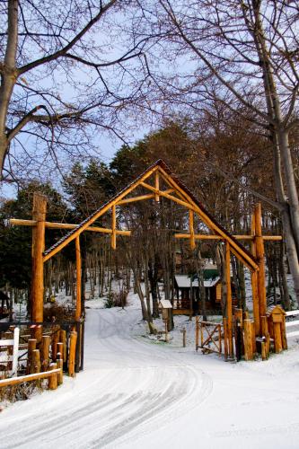 a wooden arch in the snow with trees at Aldea Nevada in Ushuaia