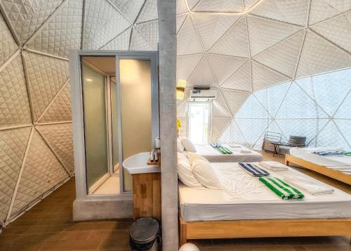 a room with two beds and a sink and a mirror at FarmKO Glamping in Dolores