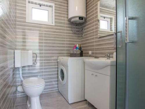 a bathroom with a washing machine and a sink at Nature Beauty with pool and whirlpool in Zagvozd