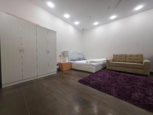 a living room with a couch and a bed at Sand Adventures Oasis in Bidiyah