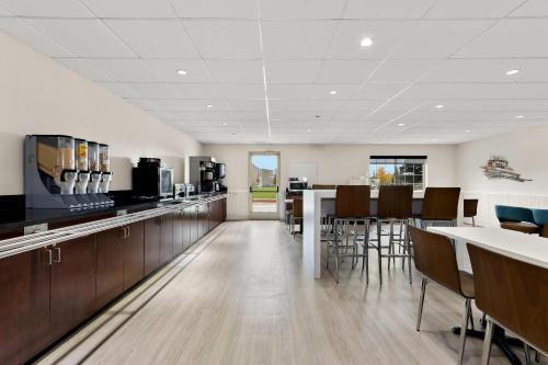 a restaurant with a bar with chairs and tables at Clarion Suites Anchorage Downtown in Anchorage