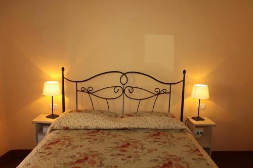 モンテカティーニ・テルメにあるAffittacamere Gir di Muraのベッドルーム1室(ベッド1台、ランプ2つ、テーブル2台付)