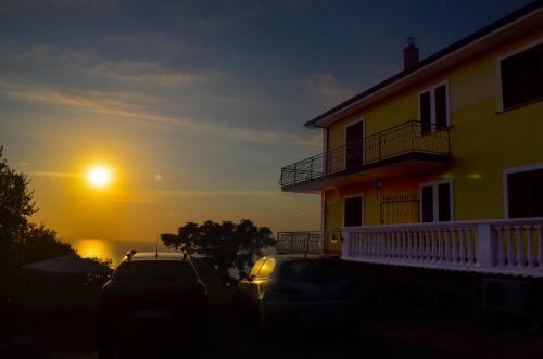 a house with cars parked in front of a sunset at Villa Malandrino Guest House in Agropoli