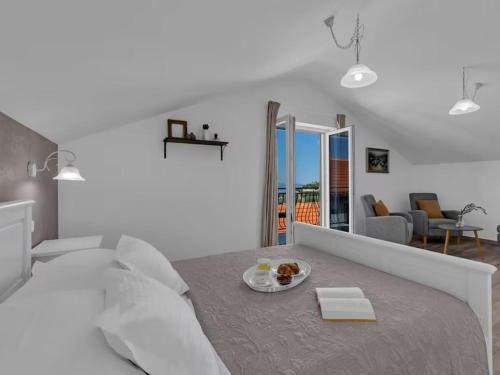 a white bedroom with a plate of food on a bed at Rustic Villa Nina Tucepi in Tučepi
