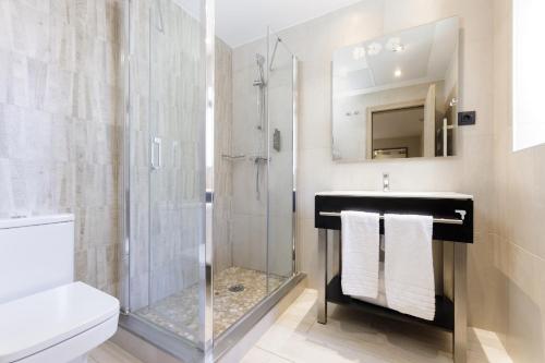 a bathroom with a glass shower and a sink at Hotel Civera in Teruel