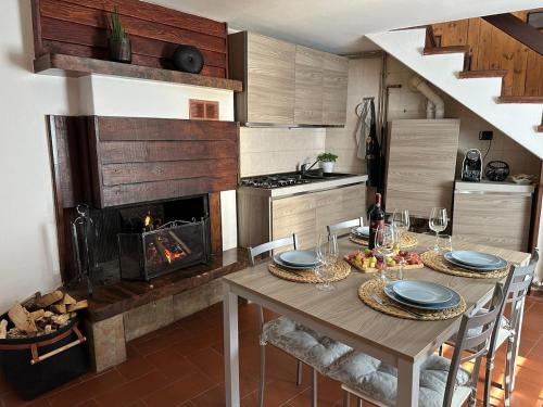 a kitchen with a table with chairs and a fireplace at Dina’s Flower House in Lierna