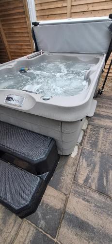 a bath tub with water in it sitting on the ground at Sally's at Number 73 with Private Hot Tub & Sauna in Coleraine