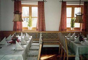 a dining room with tables and chairs and windows at Gasthof zur Sonne in Jettingen-Scheppach