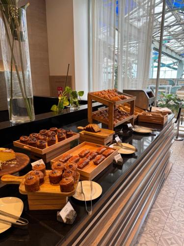 Una panadería con muchos tipos diferentes de donas en exhibición. en Alliance Palace In Batumi, en Batumi