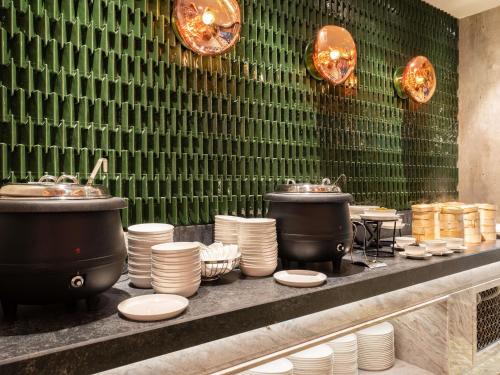 uma linha de buffet com panelas, frigideiras e pratos em Mercure Miri City Centre em Miri