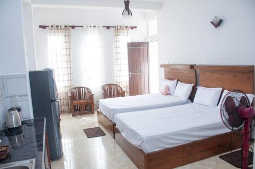 a bedroom with two beds and a refrigerator at Apartment Room - Mathara in Matara