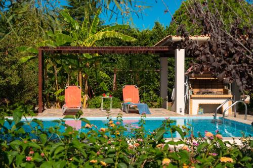 une piscine avec deux chaises et une table dans l'établissement The Moon House, à Prévéza