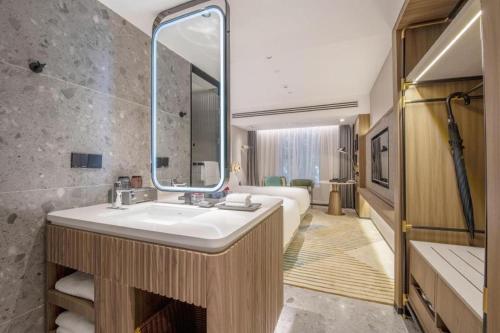 a bathroom with a sink and a large mirror at Aden Select Shenzhen Taizi in Shenzhen