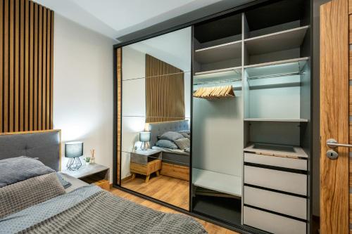 a bedroom with a bed and a glass closet at Luxury apartment with WiFi and Netflix Ostrava-Jih in Hrabŭvka