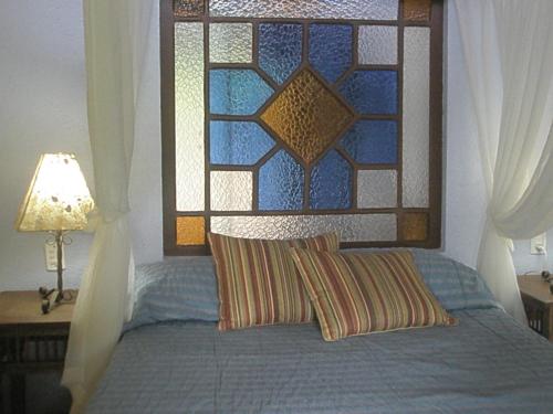 a bedroom with a bed with a stained glass window at Paraty Villa d`agua Temporada in Paraty