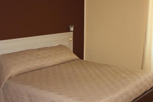 een bed in een kamer met een bruine sprei bij Mille Charme and Relais in Sassari