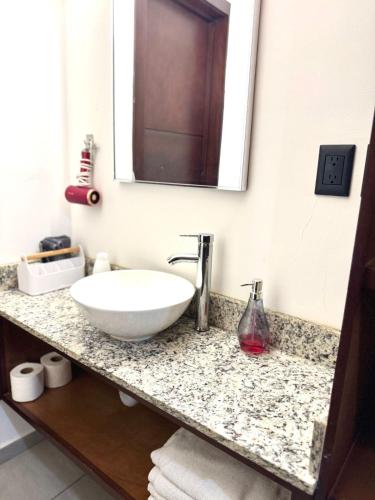 a bathroom with a white sink and a mirror at Loft, Departamento cerca del Malecon, MAZATLAN in Mazatlán