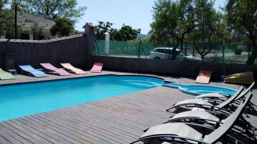 a swimming pool with lounge chairs next to a fence at Hotel Rural Los Abriles in El Toro