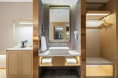 une salle de bain avec un lavabo et un miroir dans l'établissement Vienna Classic Hotel Suzhou Likou Furniture Market Metro Station, à Suzhou