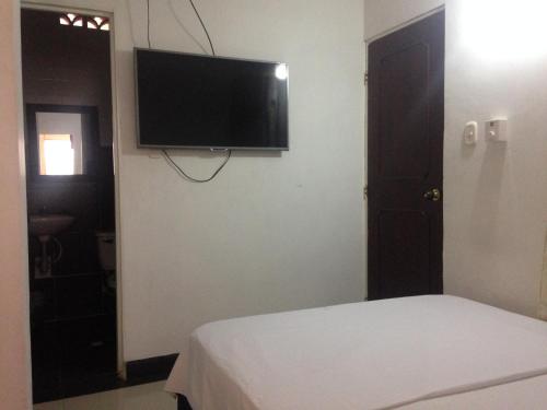 a bedroom with a flat screen tv on a wall at Hotel Arcoiris Girardot in Girardot