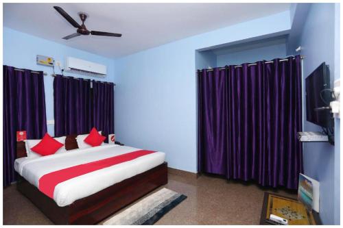 a bedroom with a large bed with purple curtains at Hotel Moonlight Palace Near Patia Railway Station-Fully Air Conditioning Hotel - Luxury & Spacious Room -A Premium Hotel in Cuttack