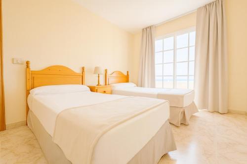 a bedroom with two beds and a window at Be six Playa La Arena in Puerto de Santiago
