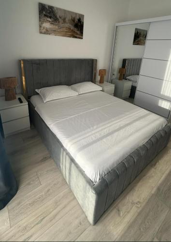 a bedroom with a large bed with white sheets at Mareea Luxury Apartment-Energia Residence in Constanţa