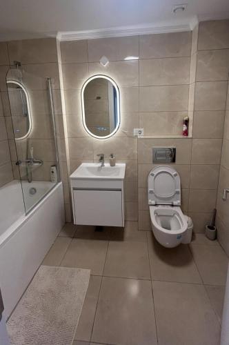 a bathroom with a sink and a toilet and a tub at Mareea Luxury Apartment-Energia Residence in Constanţa