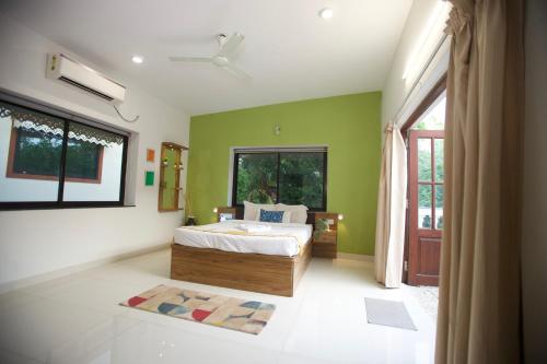 a bedroom with a bed and a large window at 4BHK Villa in Anjuna with private Jacuzzi and pool, 1KM from beach in Anjuna