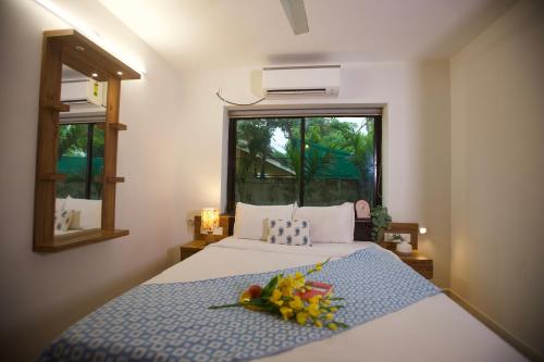 a bedroom with a bed with a flower arrangement on it at 4BHK Villa in Anjuna with private Jacuzzi and pool, 1KM from beach in Anjuna
