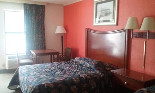 a hotel room with a bed and a desk and a window at Best Inn Formerly Known as M Star Hotel in Chickasaw