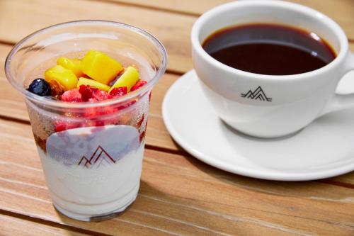 a cup of coffee next to a cup of fruit at FAV LUX Nagasaki in Nagasaki