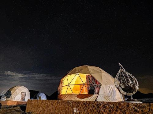 a group of domed tents under a night sky at Rum Jordan camp and tours in Wadi Rum
