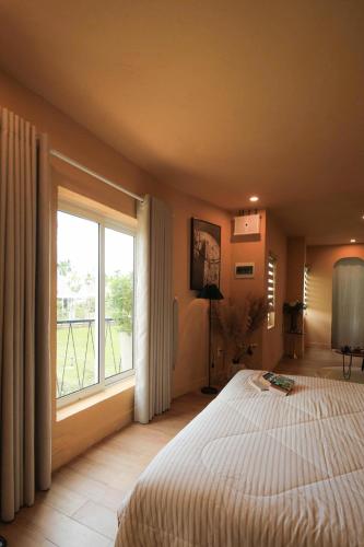 a bedroom with a bed and a large window at Amya Hoi An Cam Chau in Hoi An