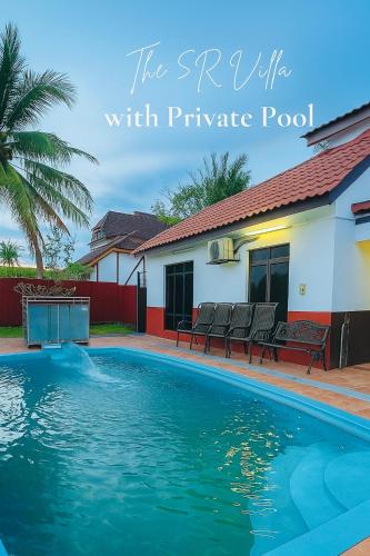 a swimming pool in front of a house at The 5R Famosa Villa in Kampong Ulu Pegoh