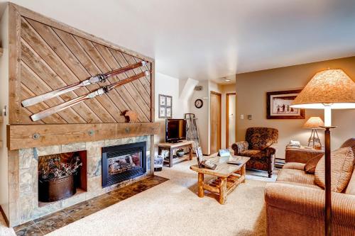 a living room with a fireplace with a wooden wall at The Forest Neighborhood by Keystone Resort in Keystone
